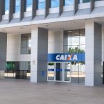 Fachada de um edifício moderno da Caixa em Brasília, com detalhes arquitetônicos visíveis.