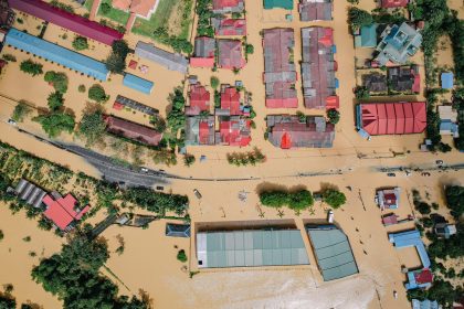 Vista aérea de casas e árvores cercadas por água após uma inundação