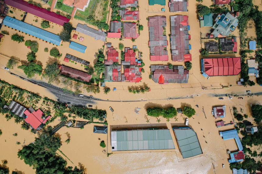 Vista aérea de casas e árvores cercadas por água após uma inundação