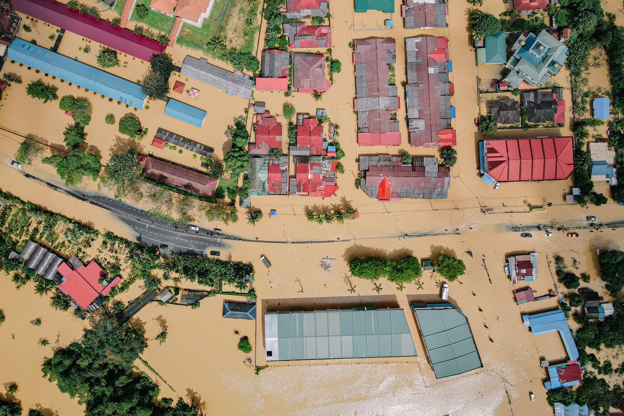 Vista aérea de casas e árvores cercadas por água após uma inundação